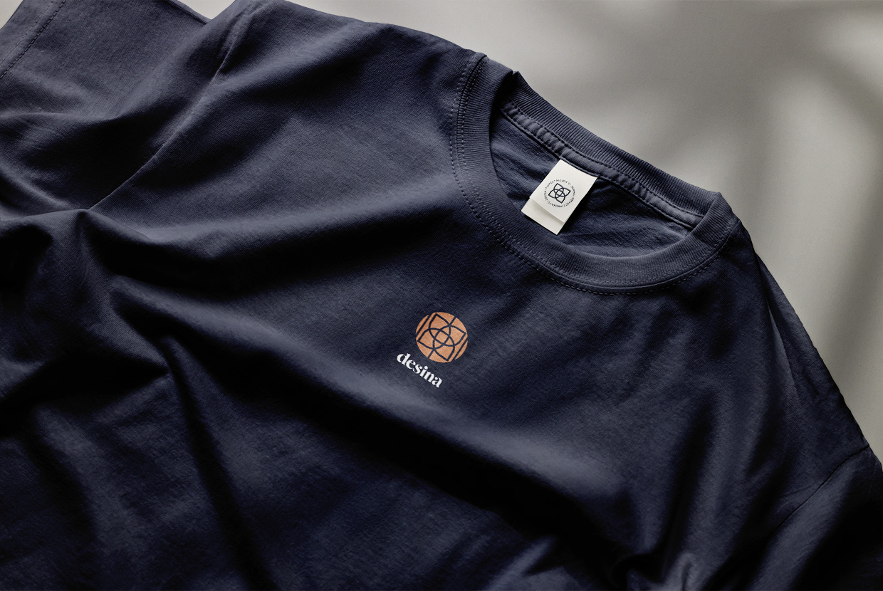 Antares Advertising - Projekt Desina - Mockup zeigt eine Nahaufnahme vom oberen Teil eines dunkelblauen T-Shirts mit Logo