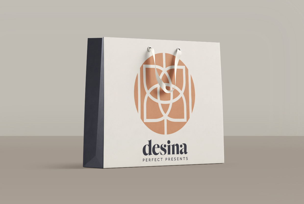 Antares Advertising - Projekt Desina - Mockup zeigt eine hochwertige Papiertragetasche im Branddesign vor einer beigen Wand