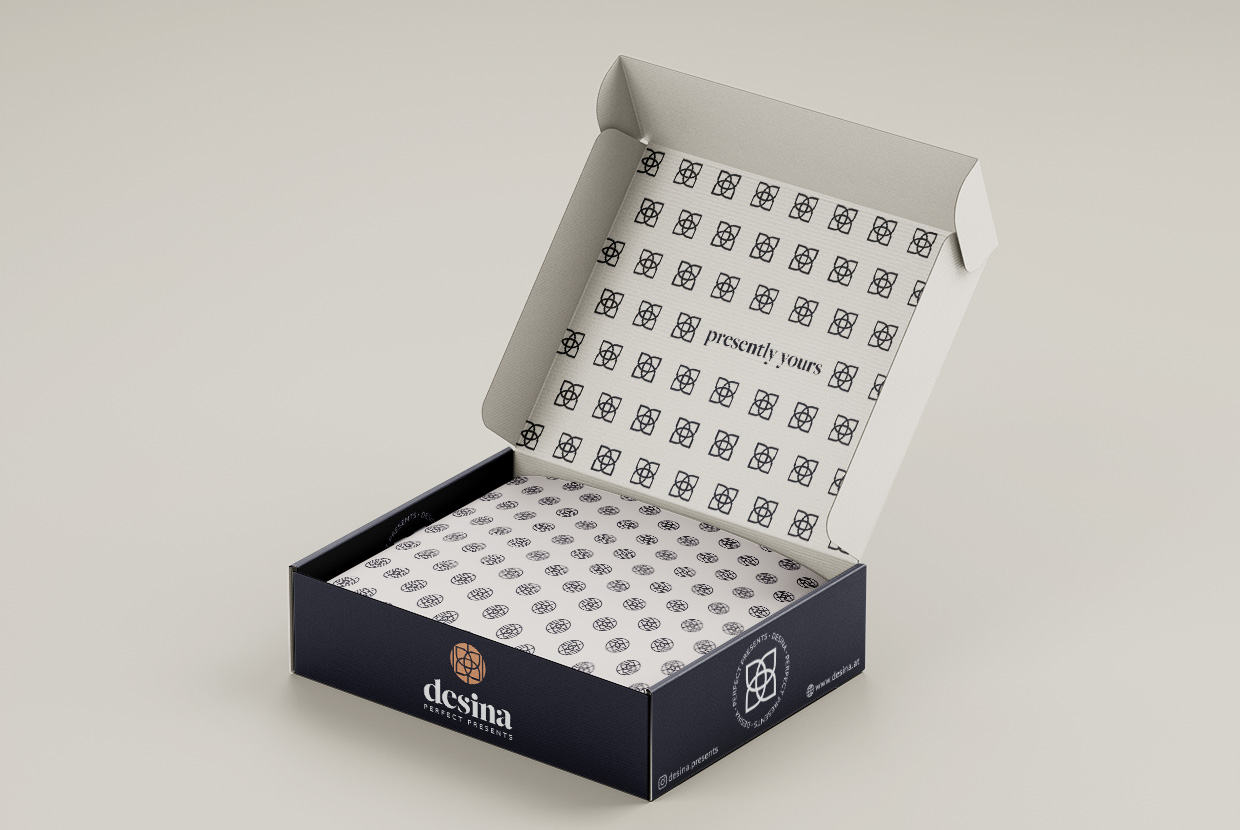 Antares Advertising - Projekt Desina - Mockup zeigt eine gebrandete Geschenkeschachtel die aufgeklappt auf einer beigen Fläche steht und Verpackungspapier beinhaltet