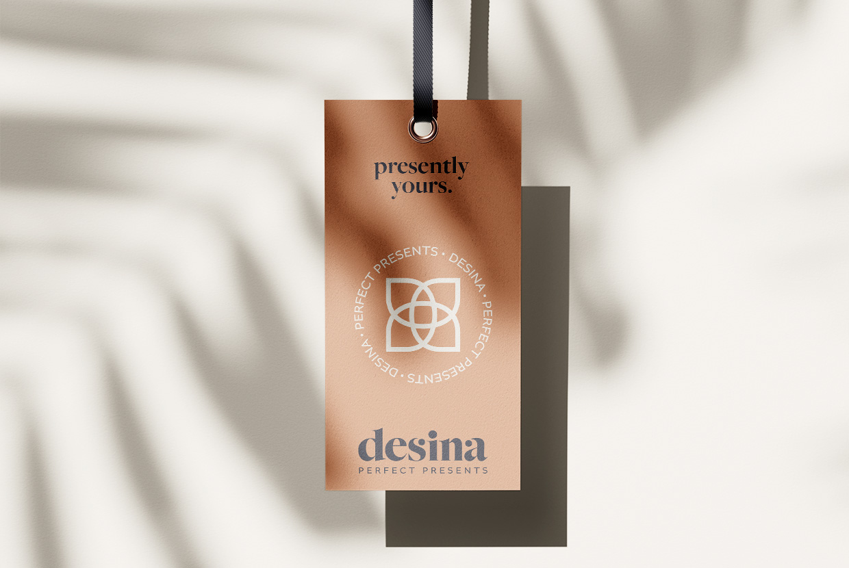 Antares Advertising - Projekt Desina - Mockup zeigt ein vor einer beigen Wand hängendes Label-Tag, darüber liegt ein Schatten einer Pflanze